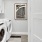 a white room with a washing machine and a picture on the wall at The Pullman Apartments in Denver, CO near Union Station