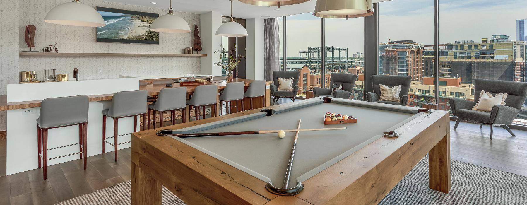 a room with a pool table and chairs