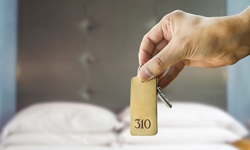 Prospective resident holding keys to model apartment for self-guided tour