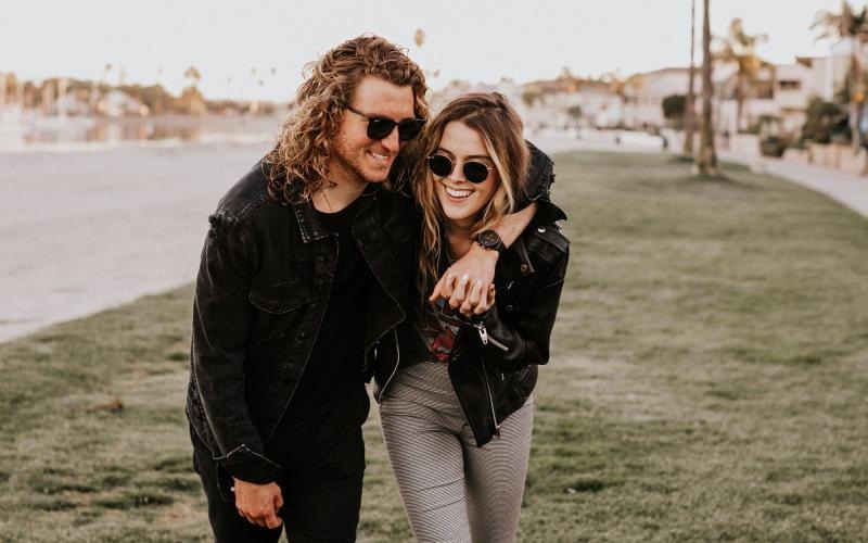 a couple walks on grassy area in open neighborhood lot