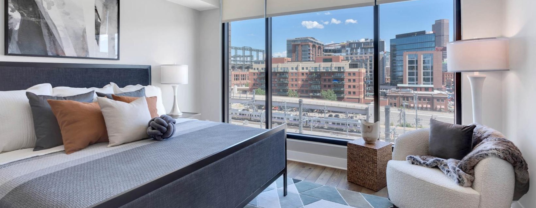 a bedroom with a view of the city at The Pullman Apartments in Denver, CO near Union Station